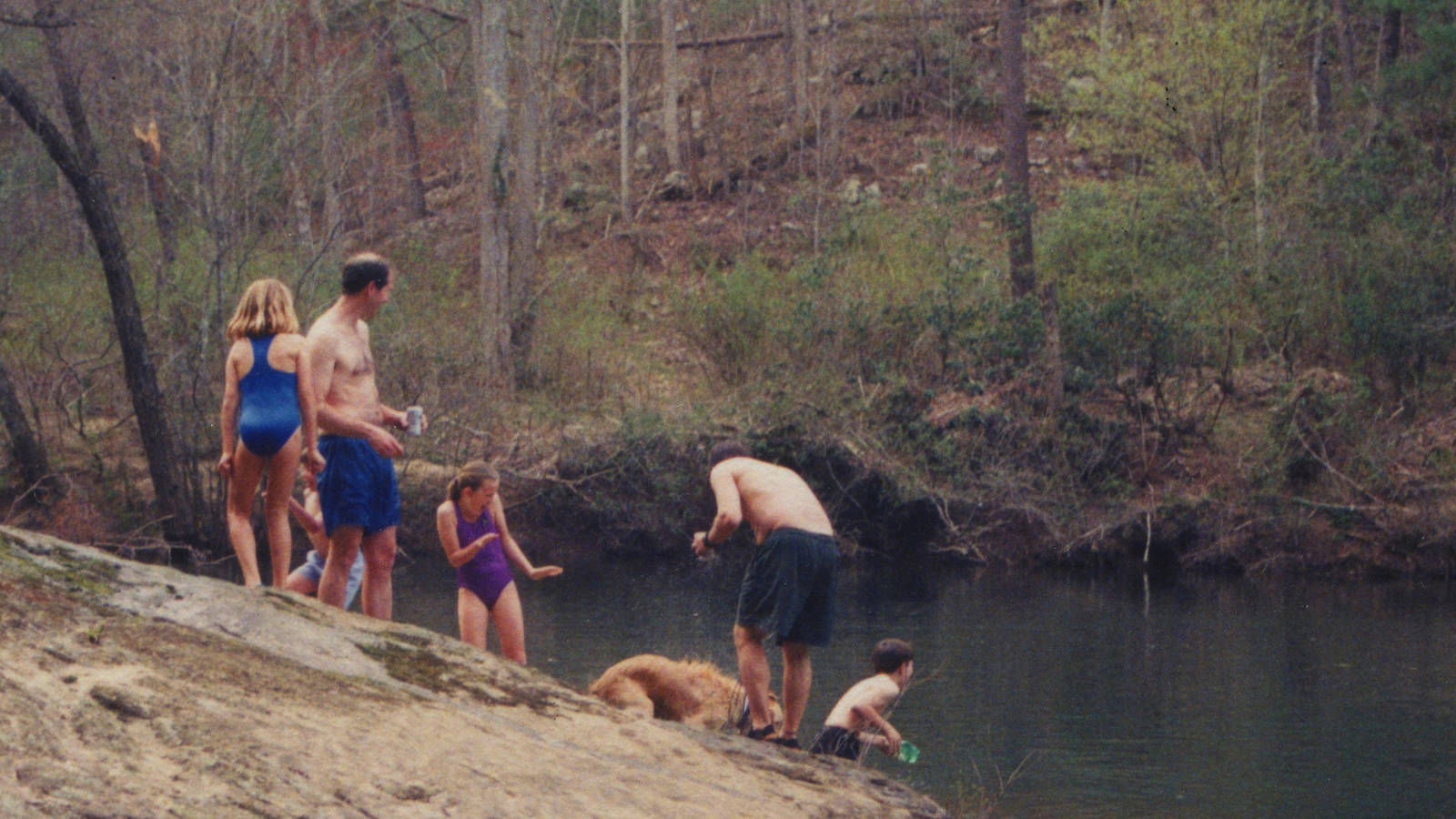 <p>The author and his longtime friend, Kent Ernsting, with their children on the “Rock of Contemplation” in Clear Creek. Benton, post-swim, shakes the water from his fur. </p>