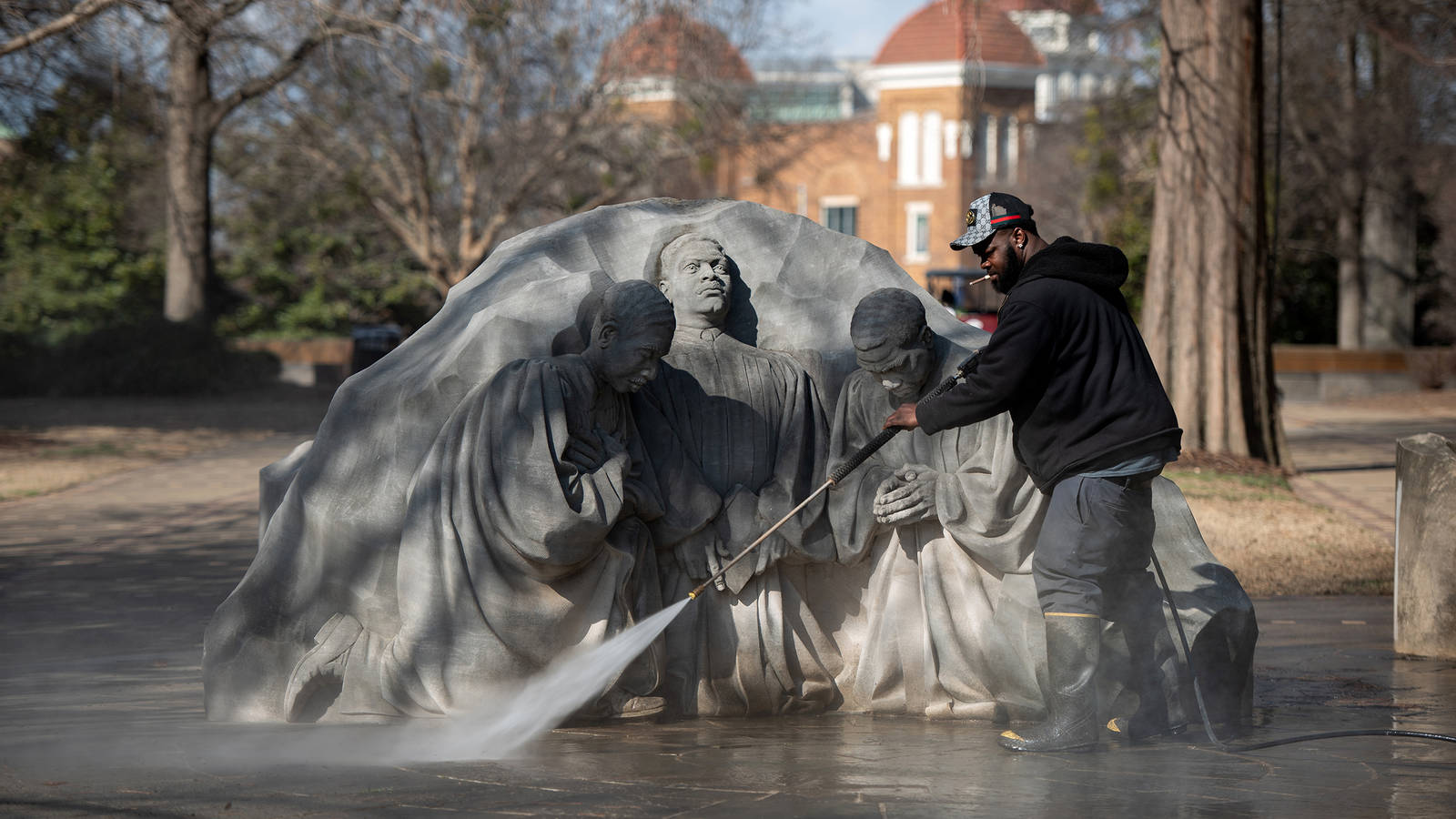 <p>A worker power-washes the Three Ministers Kneeling statue in Kelly Ingram Park in Birmingham. The scene immortalizes the moment in 1963 when clergy members, who were leading a Palm Sunday protest march, knelt to pray when faced with imminent violence.</p>
