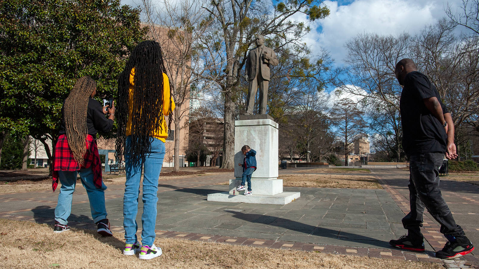 <p>Nia Davis (left) photographs her son, Mason, next to the statue of Martin Luther King Jr.</p>