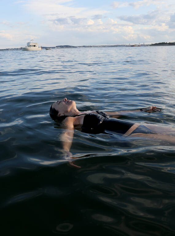 <p>Ana Hoffman floats in the bay off Peddocks Island.</p>