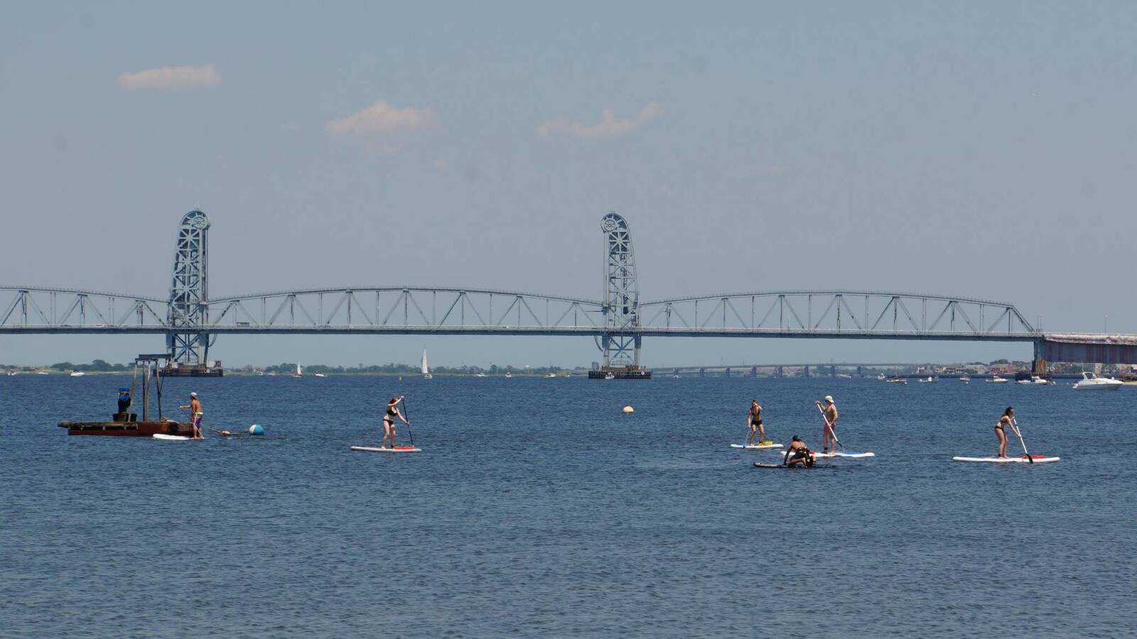 <p>Visitors stand up paddle boarding in Jamaica Bay under the Marine Parkway Bridge, just feet away from where the Army Corps’ is proposing a flood gate that would wall in recreational activities like these. </p>