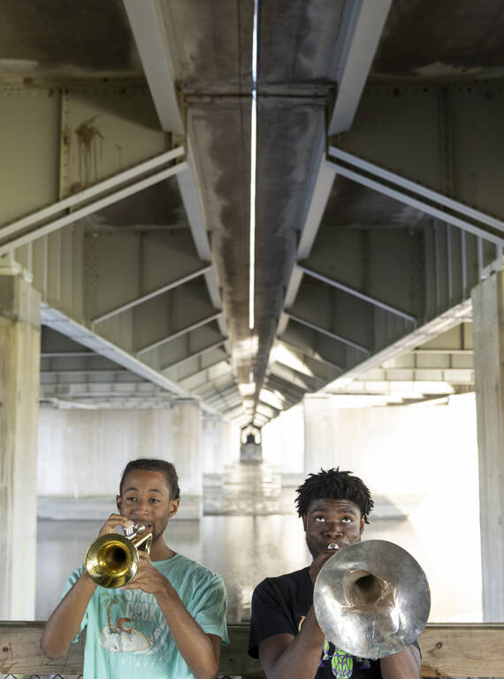 <p>Makhi Smith, 19, (left) and Malik Terrell, 20, practice their instruments underneath the Whitney Young Memorial Bridge, which spans the river near the defunct Robert F. Kennedy Memorial Stadium.</p>