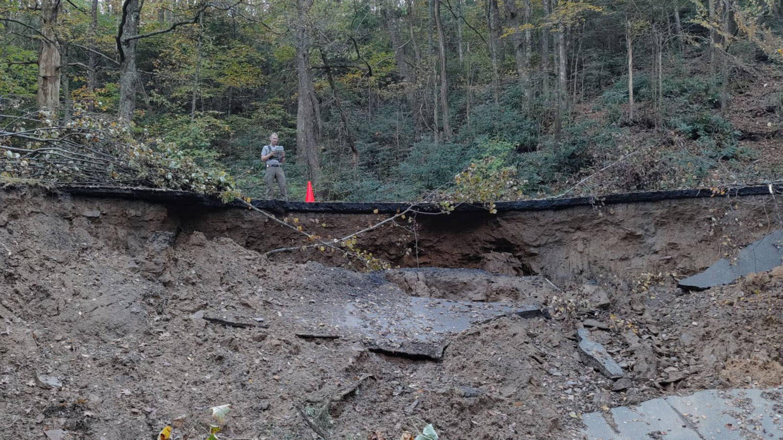 <p>A National Park Service employee assesses a washout under the Blue Ridge Parkway at milepost 345. </p>