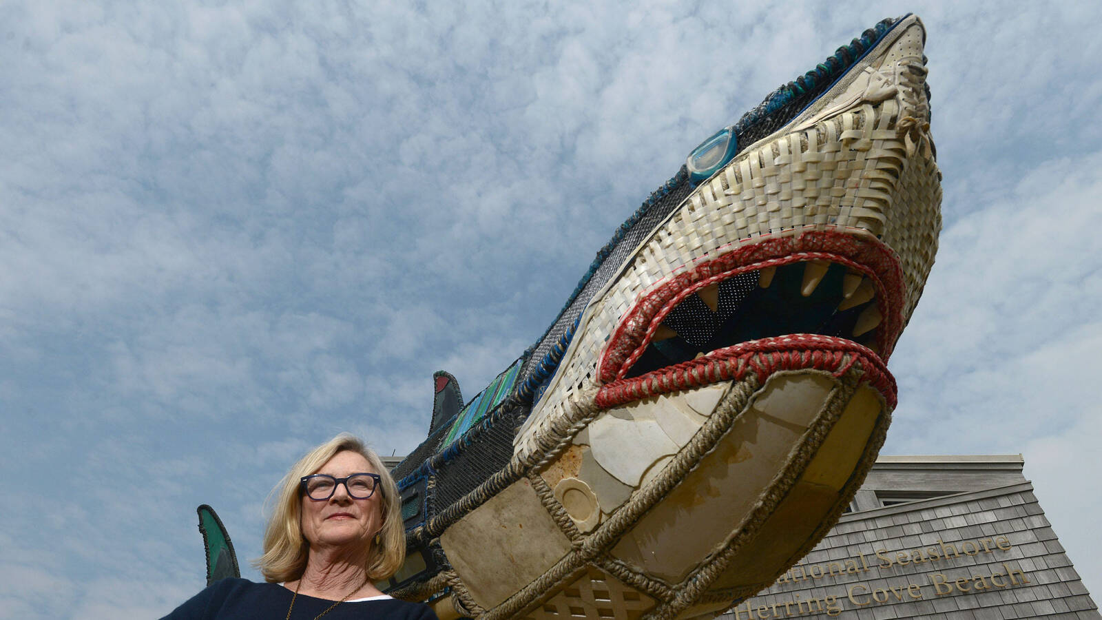 <p>Artist Cindy Pease Roe stands beside her marine debris creation, Mama Shug, at Cape Cod National Seashore.</p>