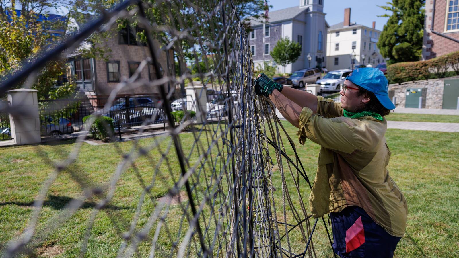 <p>Artist Elaine Alder works on the exhibit at New Bedford Whaling National Historical Park. Titled "The Water We're Swimming In," Alder's creation shows whales breaching out of the ground at Captain Paul Cuffe Park, part of the New Bedford Whaling Museum.</p>