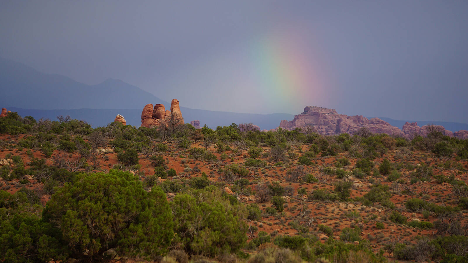 <p>A rainbow cresting over the Windows Section at Arches National Park. </p>