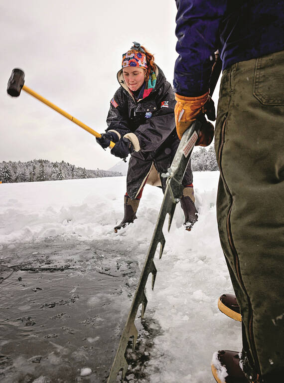 <p>Mariah Reading and Gail Gladstone, two of the group’s founders, use a sledgehammer and an ice saw to create an ice hole for dipping at Long Pond.</p>