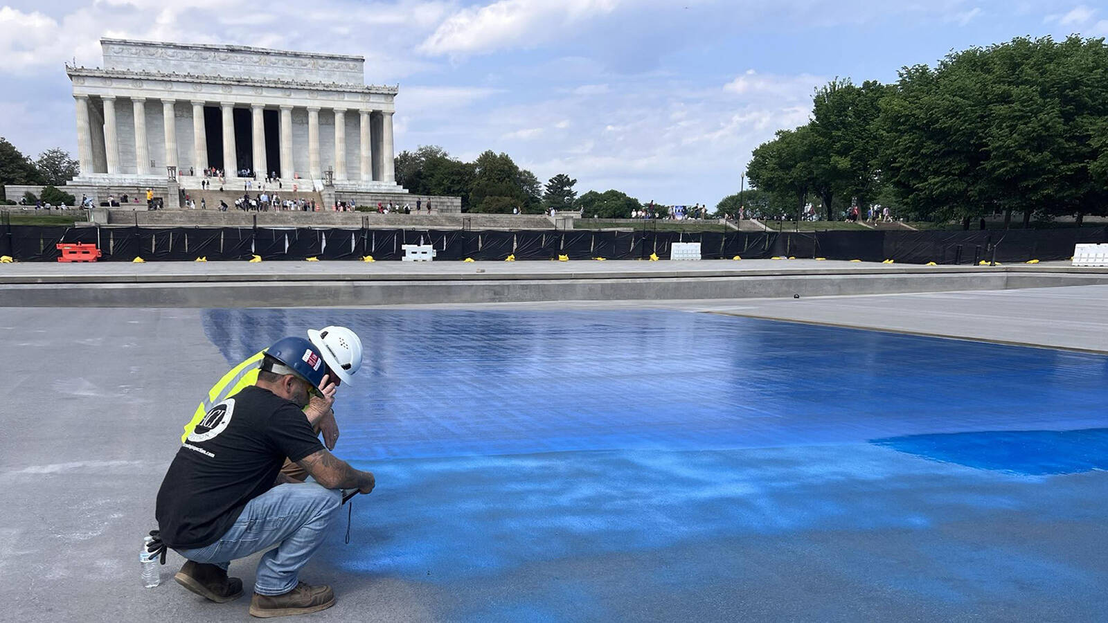 <p>Workers apply blue paint to the Lincoln Memorial Reflecting Pool in spring 2026.</p>
