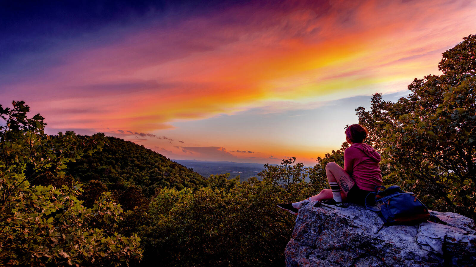<p>A hiker takes in the view from Balanced Rock in Hot Springs National Park.</p>