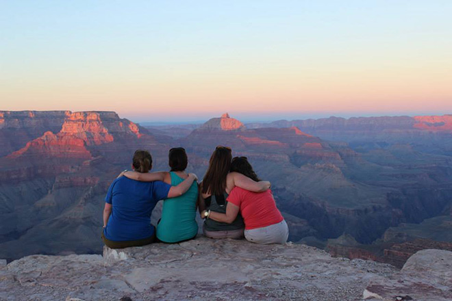 Friends enjoy the sun setting over the Grand Canyon.